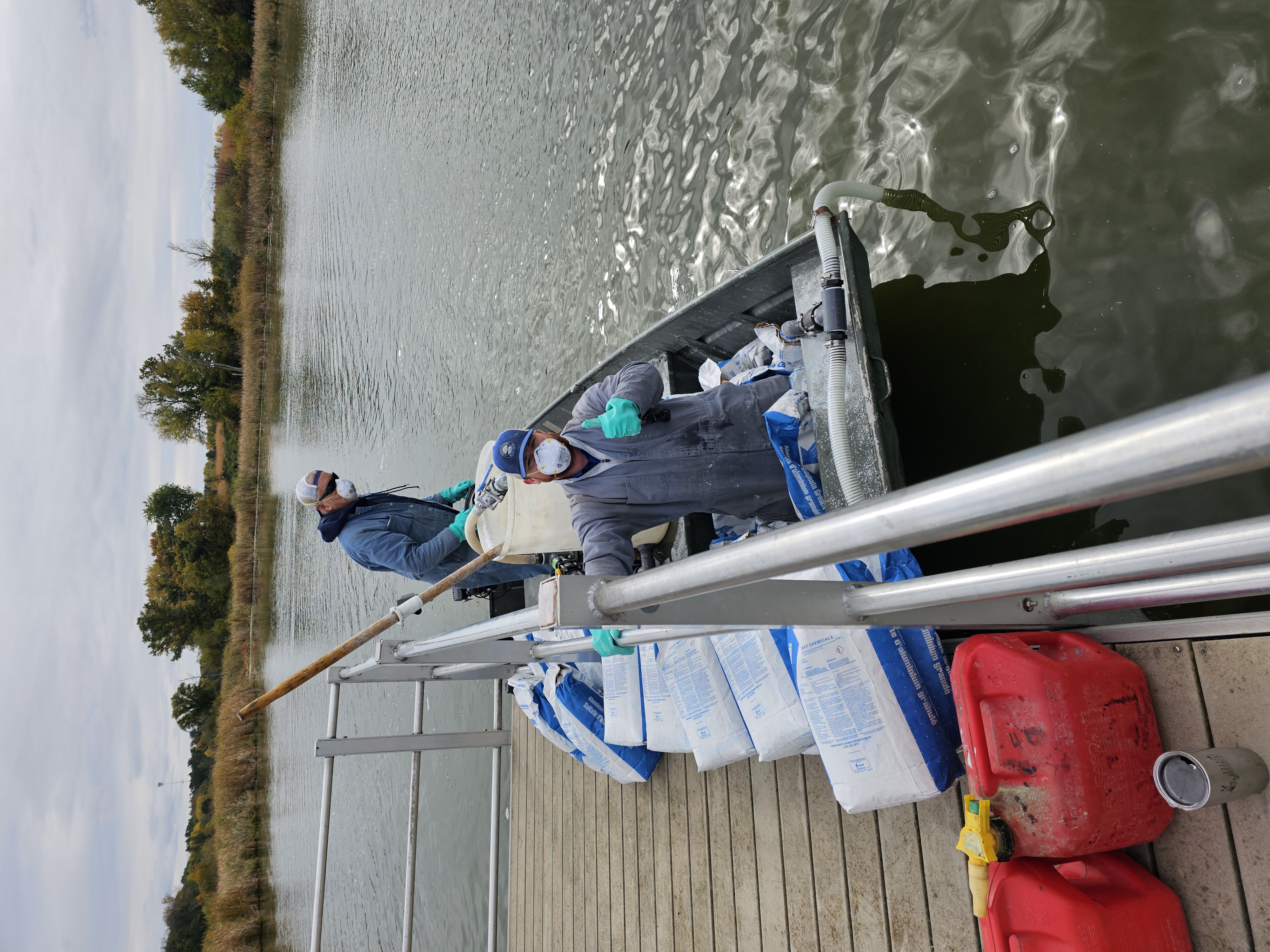 Image slide of Crew working to apply alum on Tamarack Lake. 