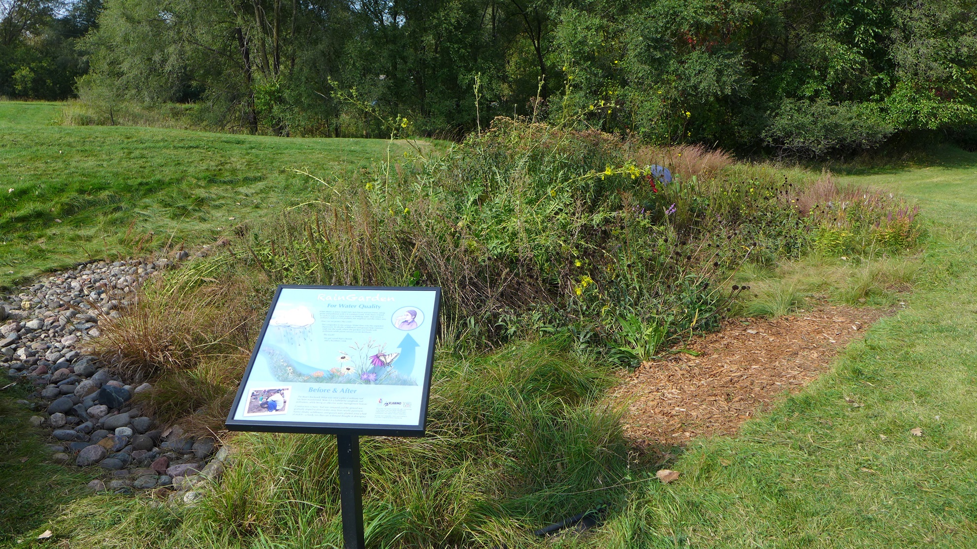 Image slide of Interpretive signage at the rain garden shares information on rain gardens. 